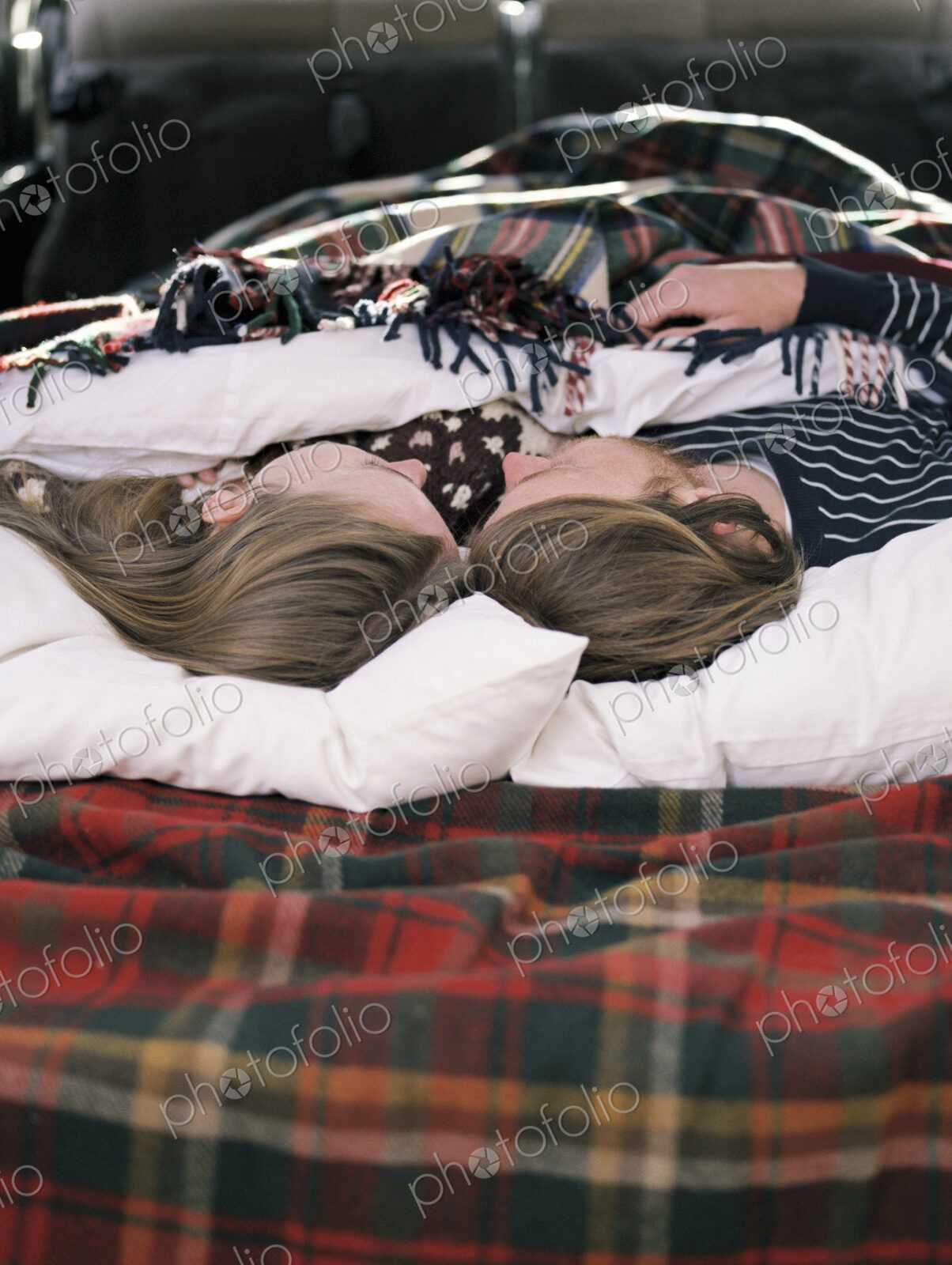 Young couple sleeping in the back of their car.
