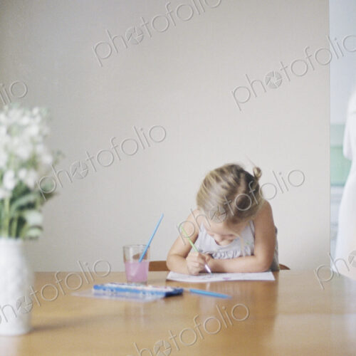 Young girl sitting at at a table, painting, a vase with white flowers, a woman in the… Young girl sitting at at a table, painting, a vase with white flowers, a woman in the…