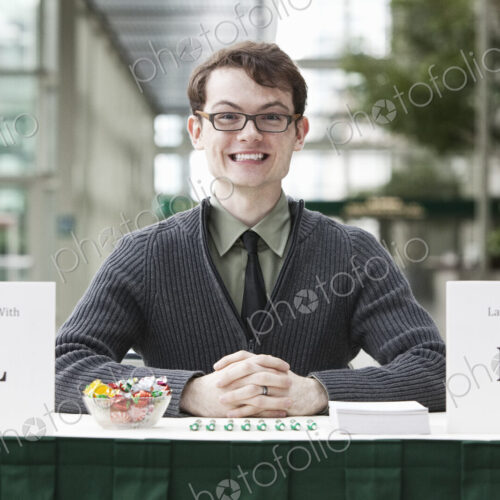 Young hip business man at a registration desk. Young hip business man at a registration desk.