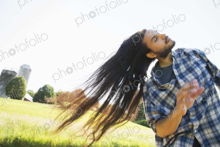 Young man shaking out his very long black hair