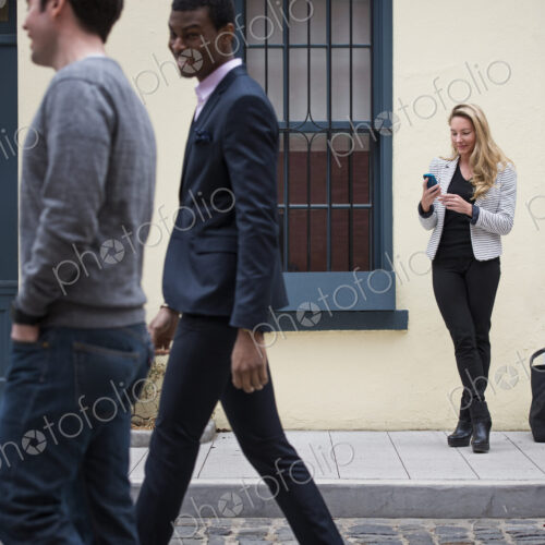 Young people outdoors on the city streets in springtime. A woman on her own, and two… Young people outdoors on the city streets in springtime. A woman on her own, and two…