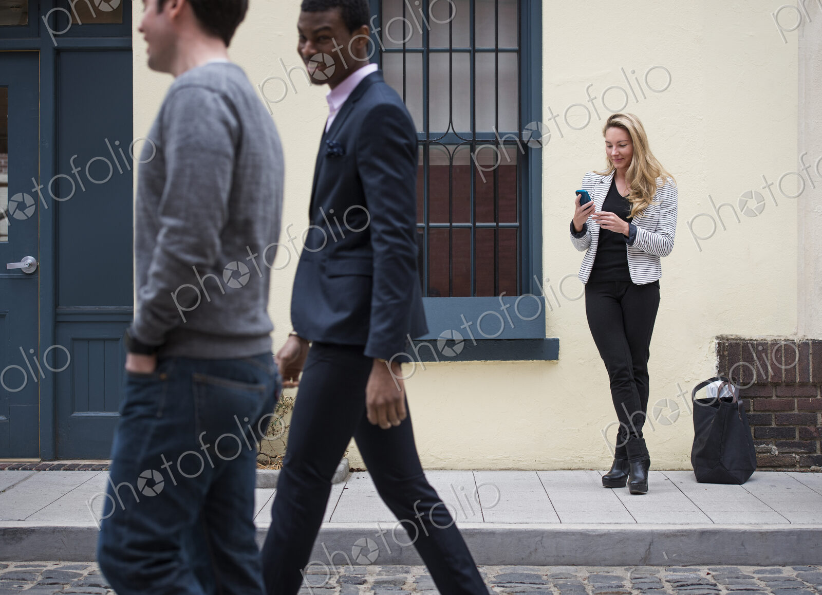 Young people outdoors on the city streets in springtime. A woman on her own, and two…