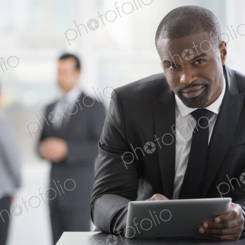 Young professionals at work. A man in a business suit, using a digital tablet. Young professionals at work. A man in a business suit, using a digital tablet.