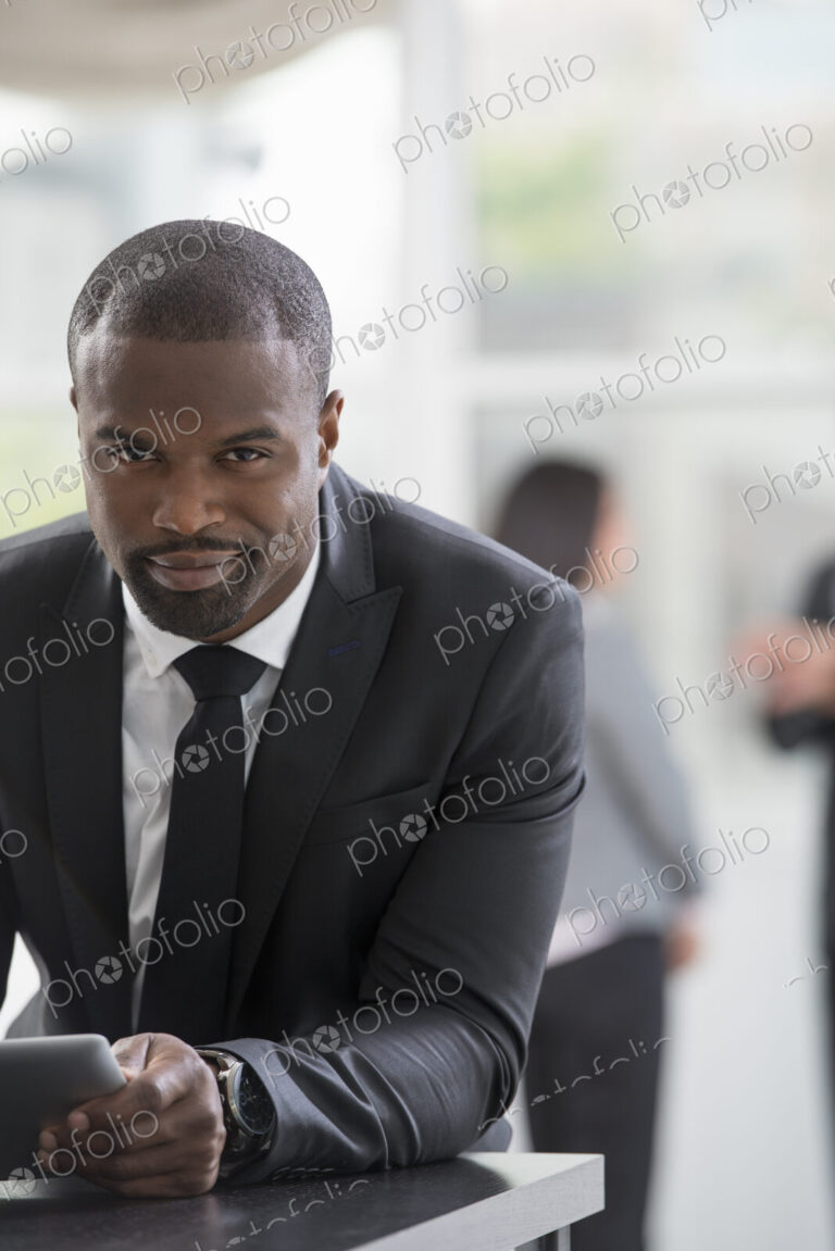 Young professionals at work. A man in a business suit, using a digital tablet.