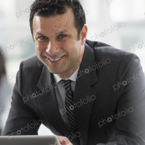 Young professionals at work. A man in a business suit, using a digital tablet. Young professionals at work. A man in a business suit, using a digital tablet.