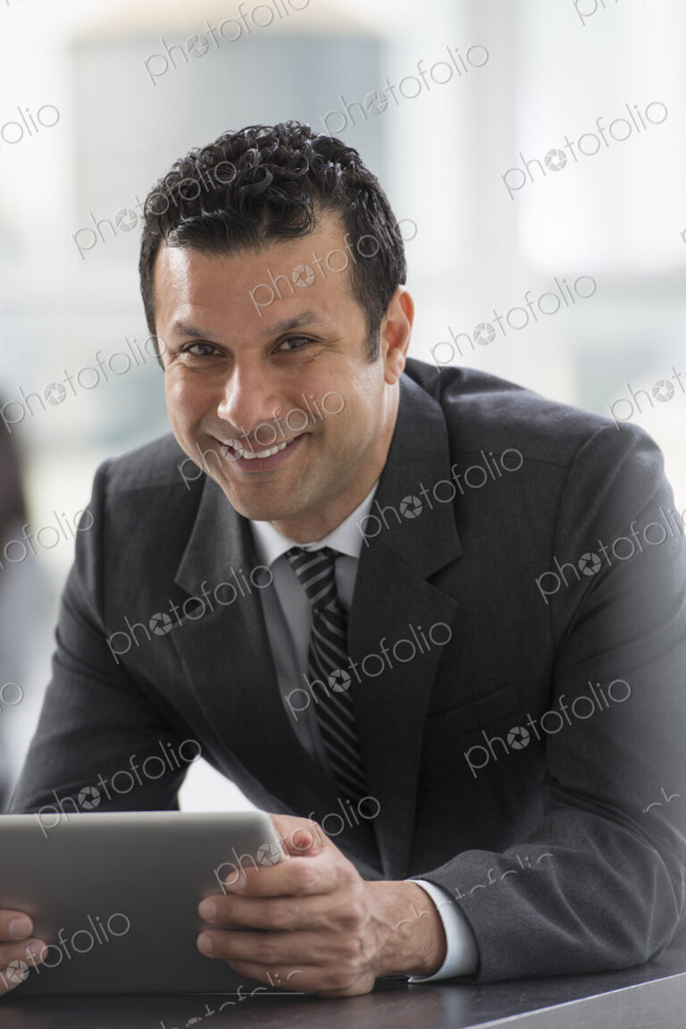 Young professionals at work. A man in a business suit, using a digital tablet.