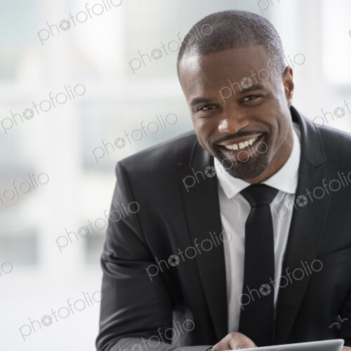 Young professionals at work. A man in a suit, sitting using a digital tablet. Young professionals at work. A man in a suit, sitting using a digital tablet.
