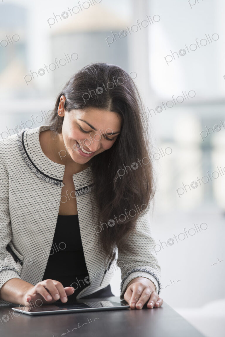 Young professionals at work. A woman at a work table using a digital tablet.