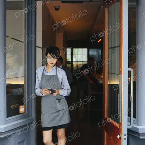 Young waitress wearing an apron at a city restaurant.