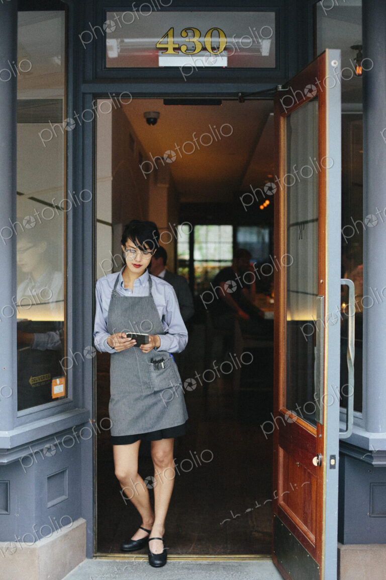 Young waitress wearing an apron at a city restaurant.