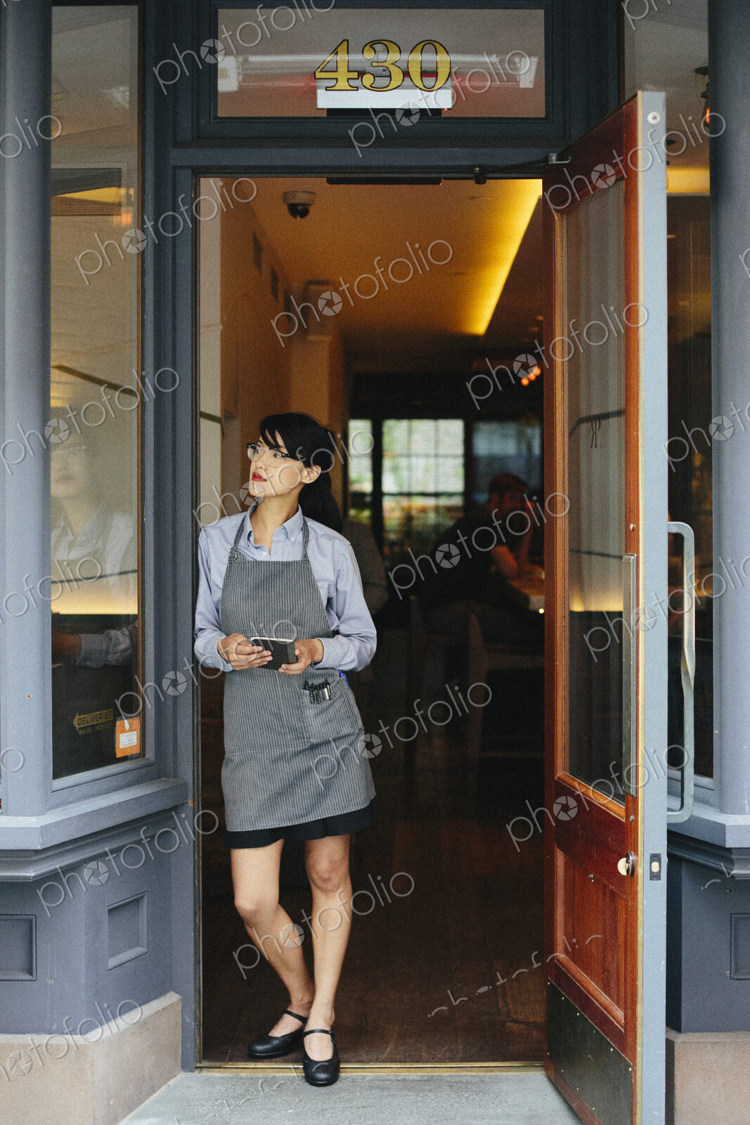 Young waitress wearing an apron at a city restaurant.