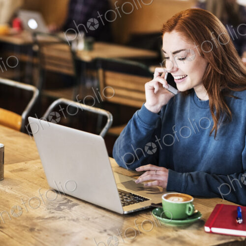 Young woman in a cafe working, using laptop and smart phone Young woman in a cafe working, using laptop and smart phone