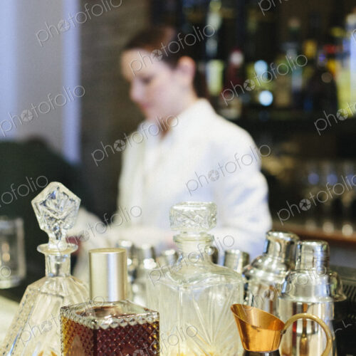 Young woman mixing a cocktail at a bar in a city restaurant.