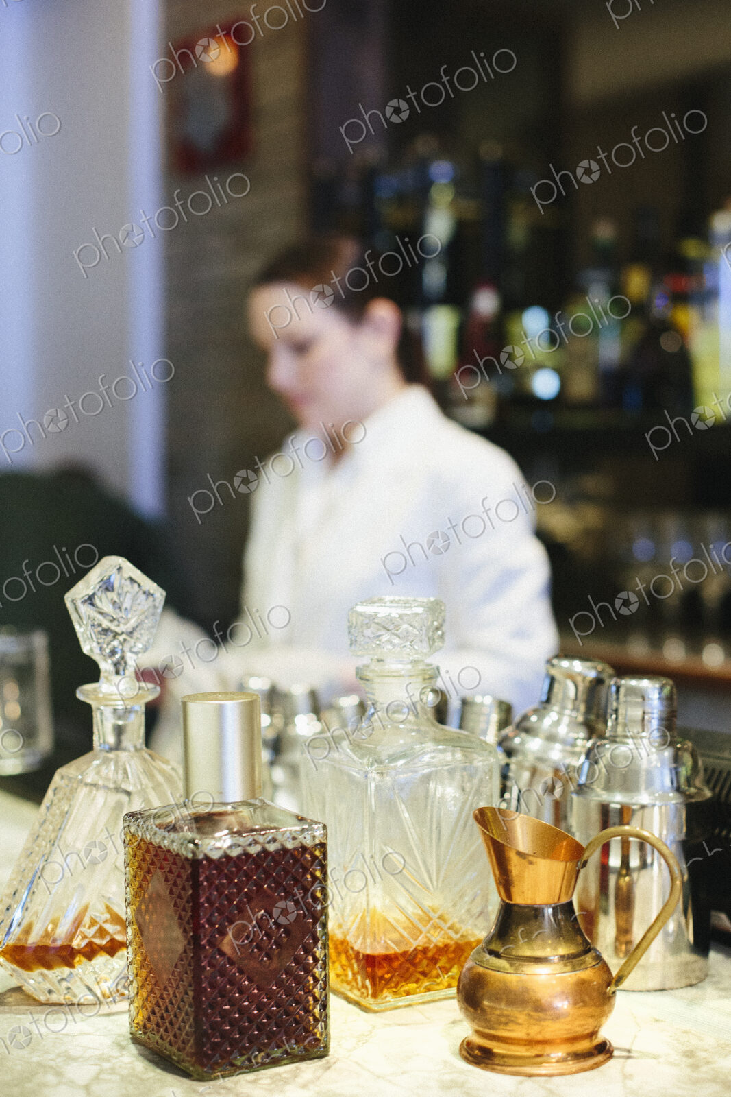 Young woman mixing a cocktail at a bar in a city restaurant.