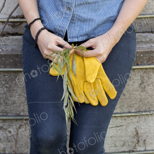 Young woman on a working farm, taking a break in the shade of a silo.