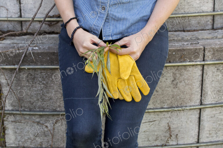 Young woman on a working farm, taking a break in the shade of a silo.