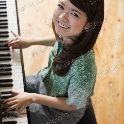 Young woman playing on a grand piano in a rehearsal studio. Young woman playing on a grand piano in a rehearsal studio.