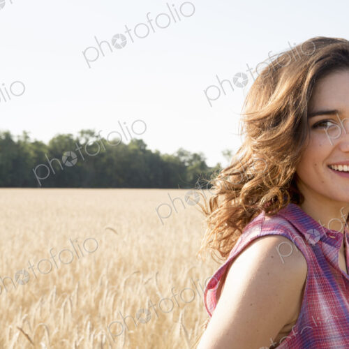 Young woman standing in a cornfield Young woman standing in a cornfield