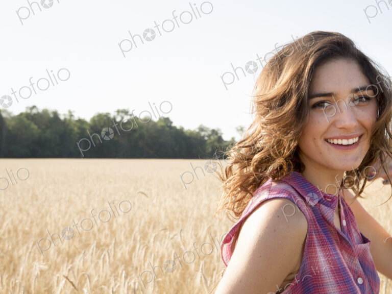 Young woman standing in a cornfield