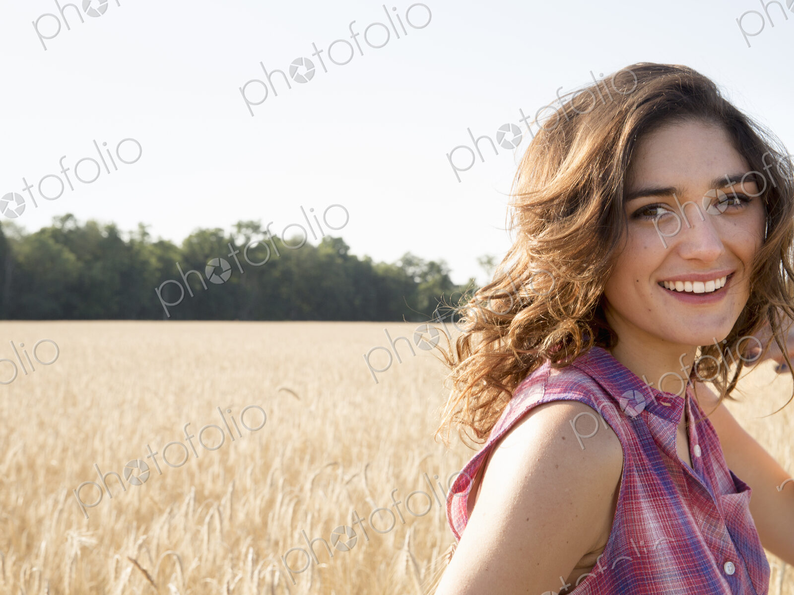 Young woman standing in a cornfield