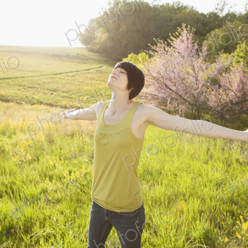 Young woman standing in grassy field in spring. Young woman standing in grassy field in spring.