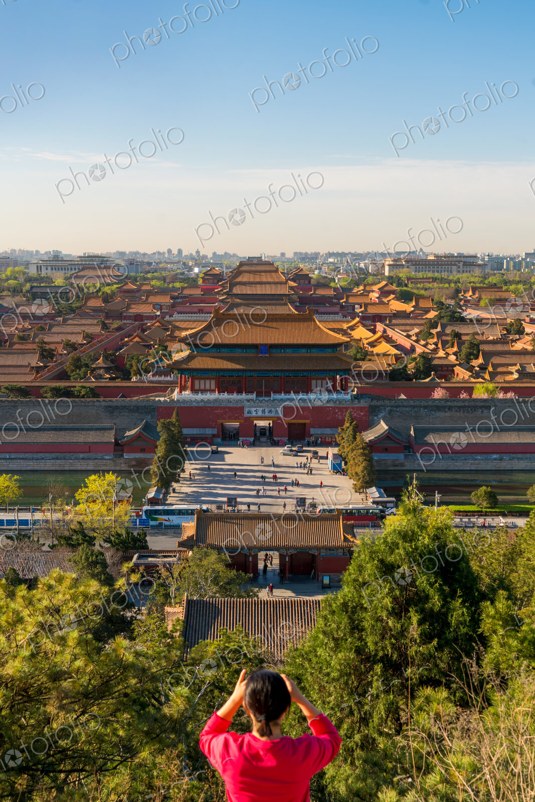 Young woman taking photograph of view over Forbidden City in Beijing, China
