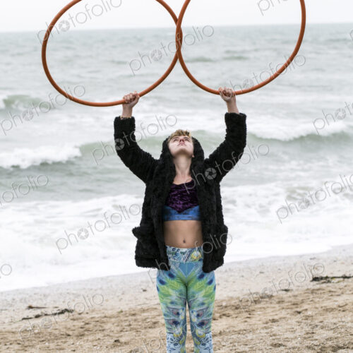Young woman with brown hair and dreadlocks standing on a sandy beach by the ocean,… Young woman with brown hair and dreadlocks standing on a sandy beach by the ocean,…