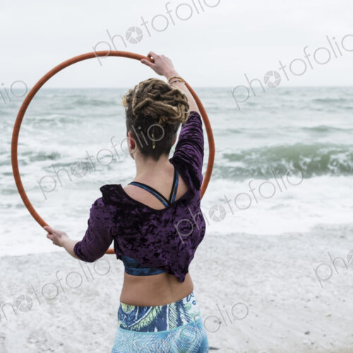 Young woman with brown hair and dreadlocks standing on a sandy beach by the ocean,… Young woman with brown hair and dreadlocks standing on a sandy beach by the ocean,…