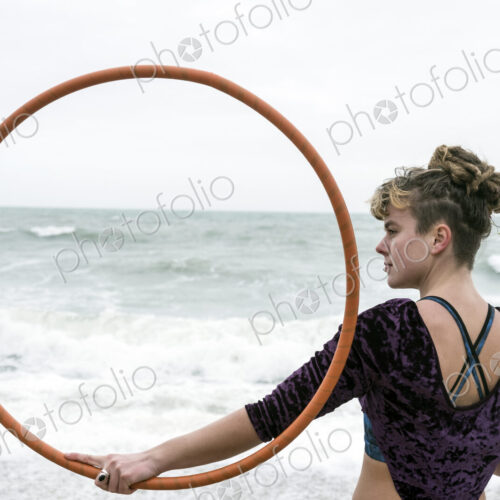 Young woman with brown hair and dreadlocks standing on a sandy beach by the ocean,… Young woman with brown hair and dreadlocks standing on a sandy beach by the ocean,…