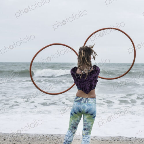 Young woman with brown hair and dreadlocks standing on a sandy beach by the ocean,… Young woman with brown hair and dreadlocks standing on a sandy beach by the ocean,…