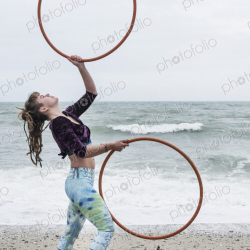 Young woman with brown hair and dreadlocks standing on a sandy beach by the ocean,… Young woman with brown hair and dreadlocks standing on a sandy beach by the ocean,…