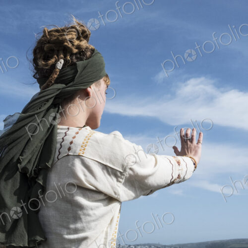 Young woman with brown hair and dreadlocks wearing headscarf standing on a beach,… Young woman with brown hair and dreadlocks wearing headscarf standing on a beach,…