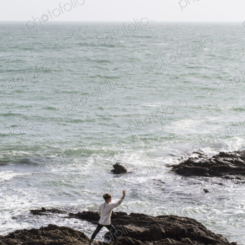 Young woman with brown hair and dreadlocks wearing white blouse standing on rocky… Young woman with brown hair and dreadlocks wearing white blouse standing on rocky…