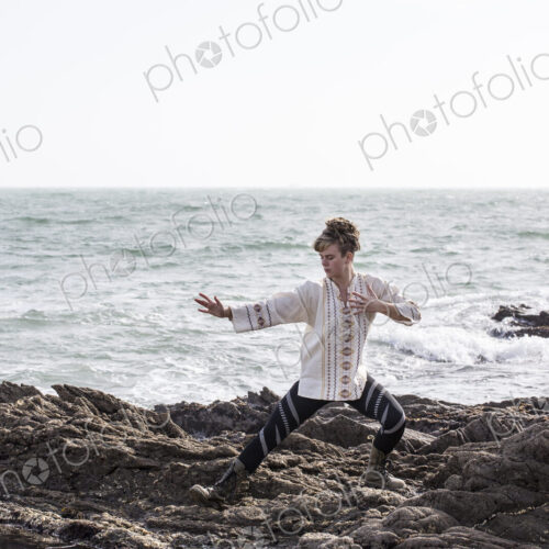 Young woman with brown hair and dreadlocks wearing white blouse standing on rocky… Young woman with brown hair and dreadlocks wearing white blouse standing on rocky…