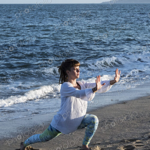 Young woman with brown hair wearing white blouse standing on a beach by the ocean,… Young woman with brown hair wearing white blouse standing on a beach by the ocean,…