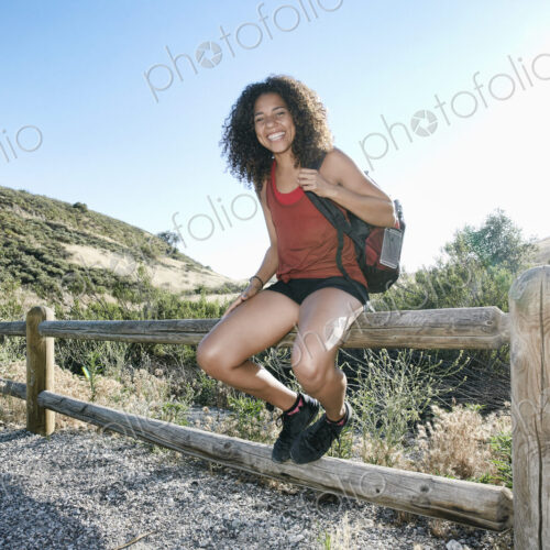 Young woman with curly brown hair hiking in urban park. Young woman with curly brown hair hiking in urban park.