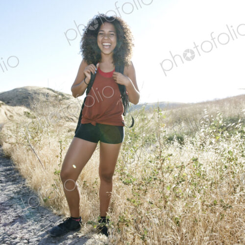 Young woman with curly brown hair hiking in urban park. Young woman with curly brown hair hiking in urban park.