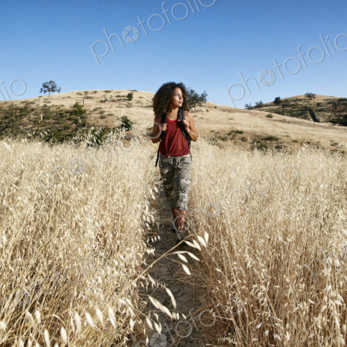 Young woman with curly brown hair hiking in urban park. Young woman with curly brown hair hiking in urban park.