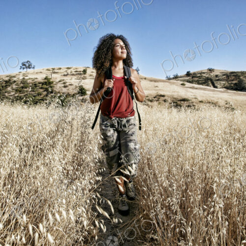 Young woman with curly brown hair hiking in urban park. Young woman with curly brown hair hiking in urban park.