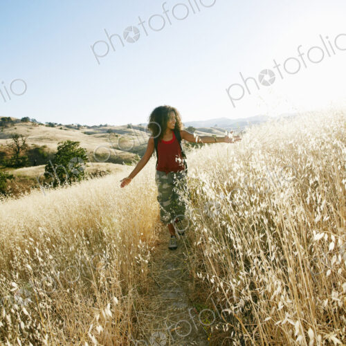 Young woman with curly brown hair hiking in urban park. Young woman with curly brown hair hiking in urban park.