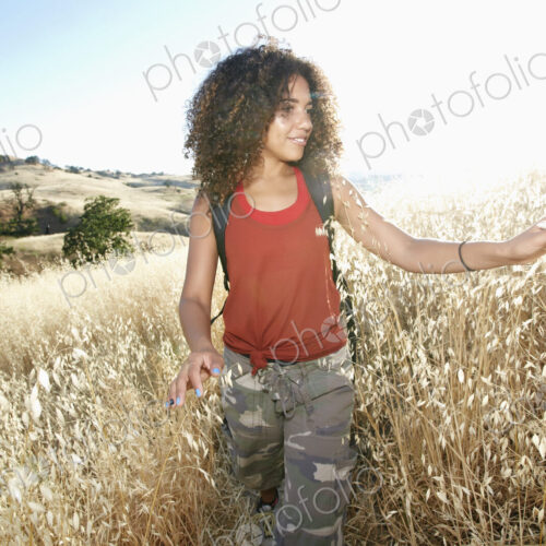 Young woman with curly brown hair hiking in urban park. Young woman with curly brown hair hiking in urban park.