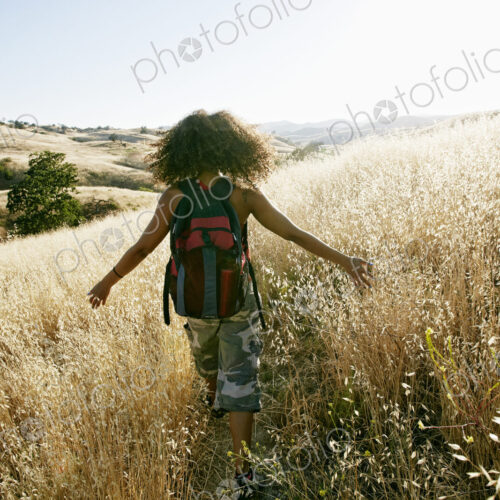 Young woman with curly brown hair hiking in urban park. Young woman with curly brown hair hiking in urban park.