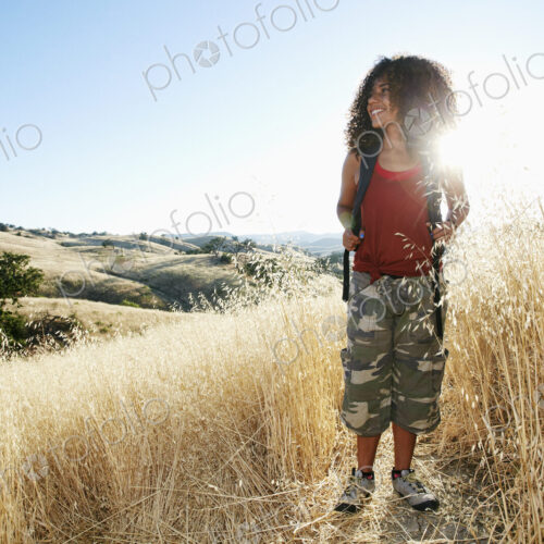 Young woman with curly brown hair hiking in urban park. Young woman with curly brown hair hiking in urban park.