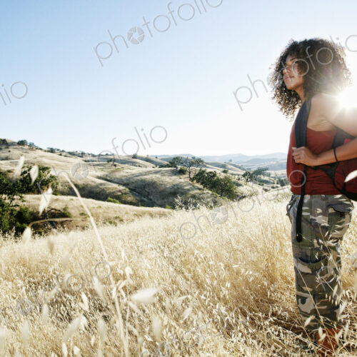 Young woman with curly brown hair hiking in urban park. Young woman with curly brown hair hiking in urban park.