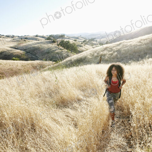 Young woman with curly brown hair hiking in urban park. Young woman with curly brown hair hiking in urban park.