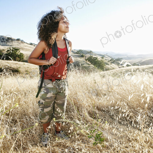 Young woman with curly brown hair hiking in urban park. Young woman with curly brown hair hiking in urban park.