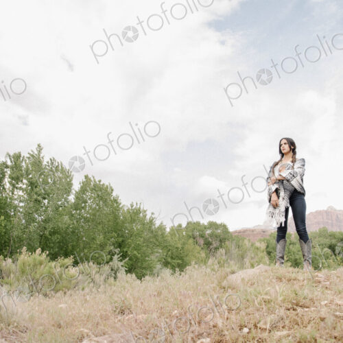 Young woman with long brown hair standing in a prairie under a cloudy sky. Young woman with long brown hair standing in a prairie under a cloudy sky.