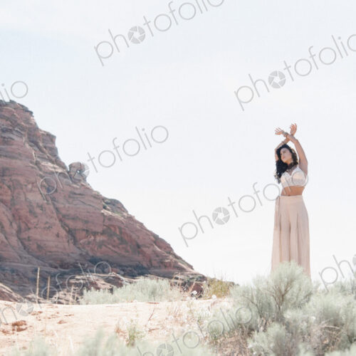 Young woman with long brown hair, wearing a long white dress, standing in the prairie. Young woman with long brown hair, wearing a long white dress, standing in the prairie.