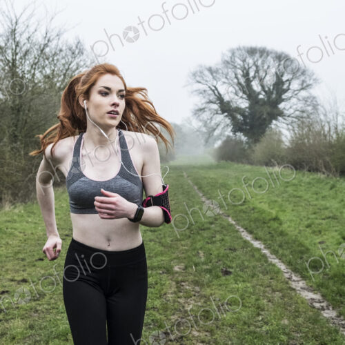 Young woman with long red hair wearing sportswear, exercising outdoors. Young woman with long red hair wearing sportswear, exercising outdoors.