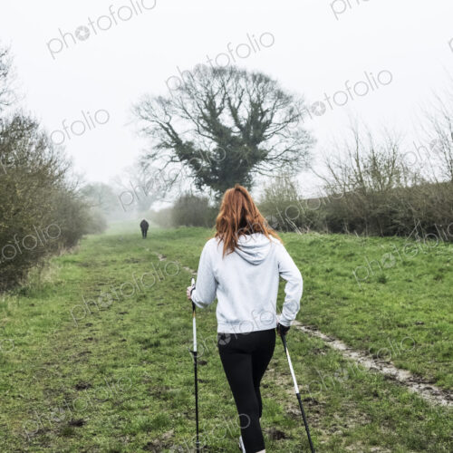 Young woman with long red hair wearing sportswear, exercising outdoors. Young woman with long red hair wearing sportswear, exercising outdoors.